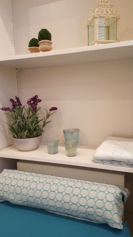 A shelf with two glasses and a plant on it.